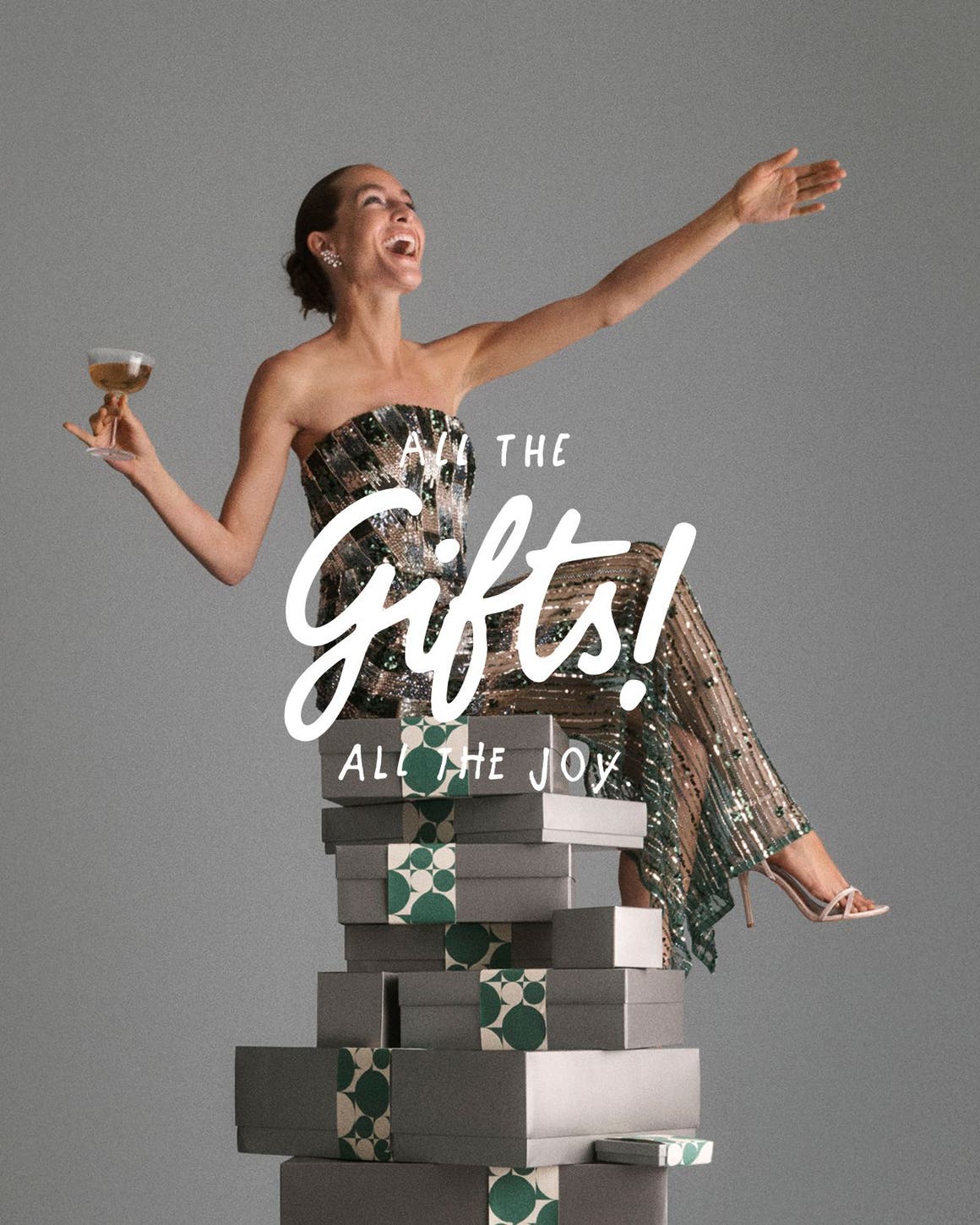 All the gifts, all the joy. A woman sitting on a tower of gift boxes.