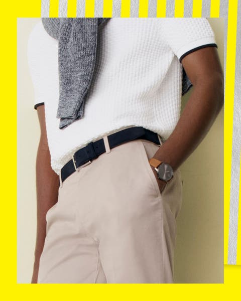 A man in khakis, a white shirt and a black leather belt.