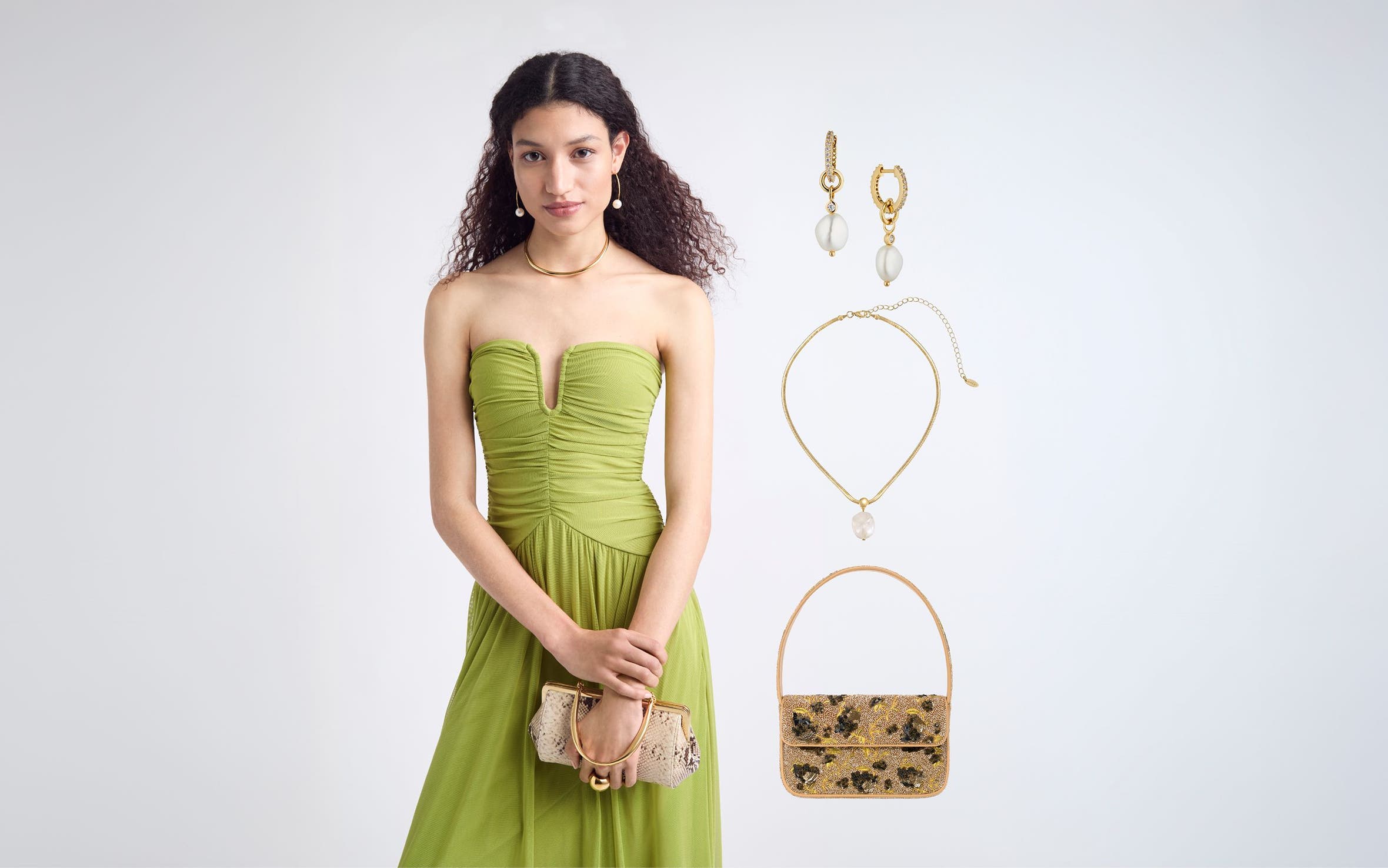 A woman in a green strapless dress with neckline detail, gold hoop necklace and snakeskin clutch.