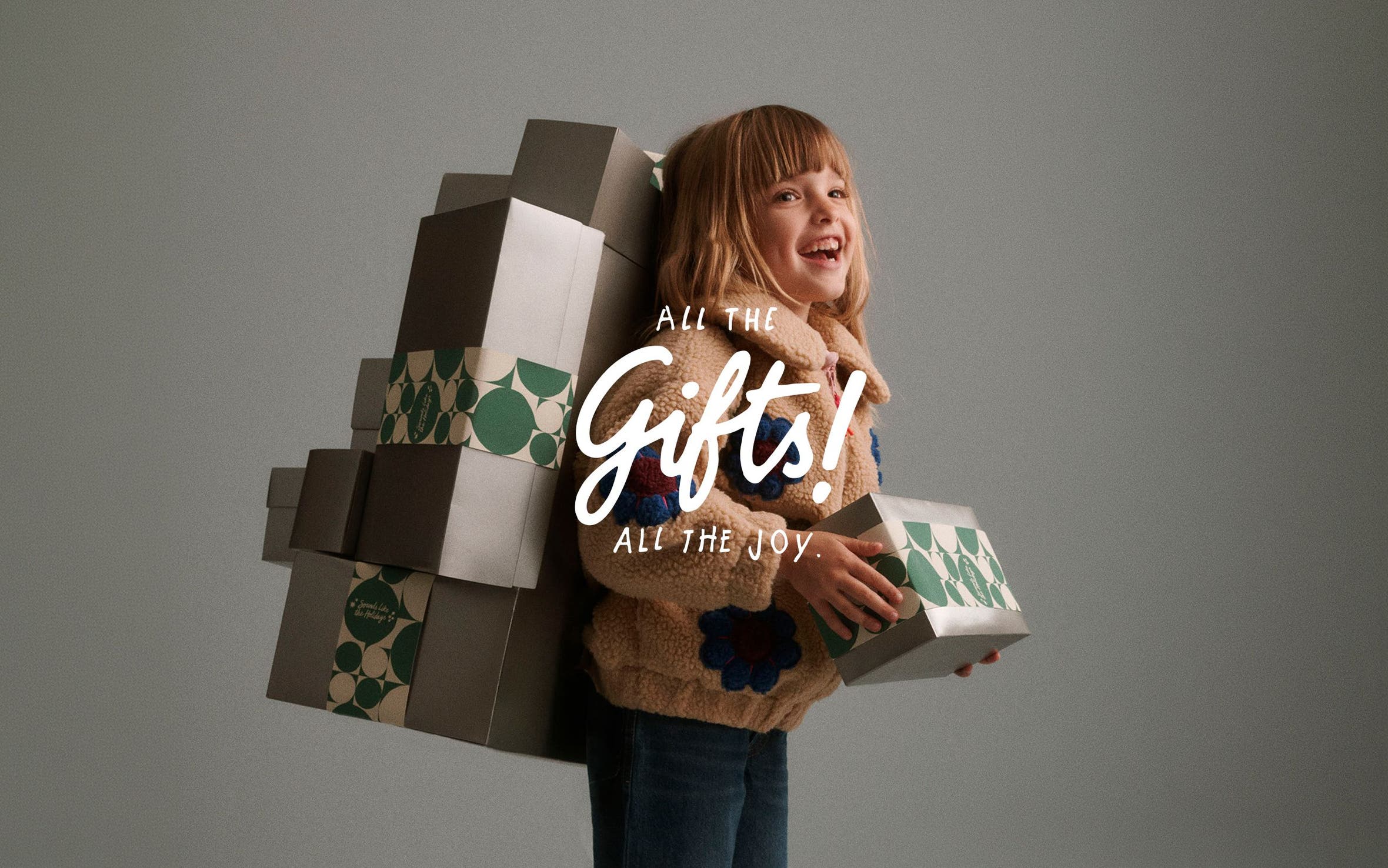All the gifts, all the joy. A girl holding gifts.