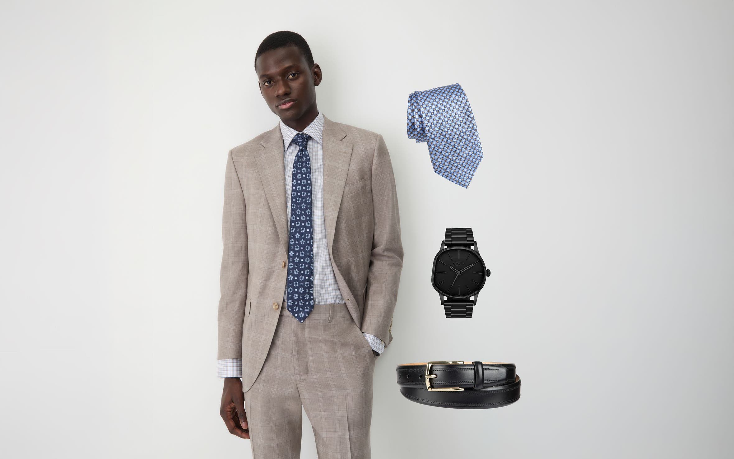 A man in a light-check linen suit and patterned blue silk tie.