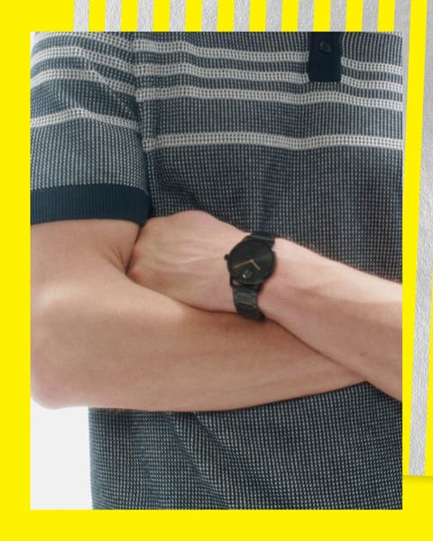 A man in a grey polo wearing a black matte watch.