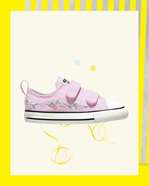Pink canvas sneakers with floral embroidery.