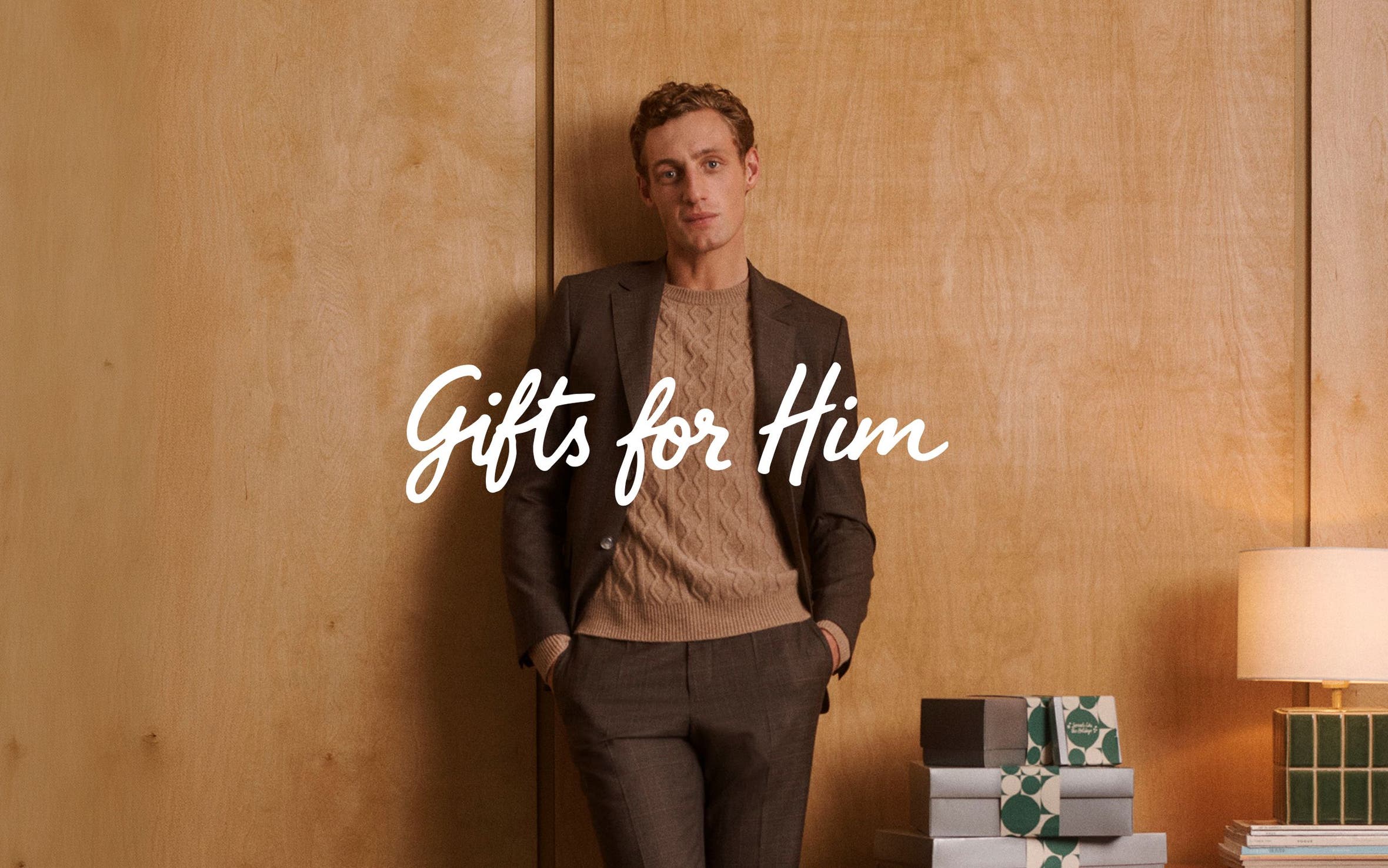 Gifts for him. A man wearing a blazer, sweater and pants.