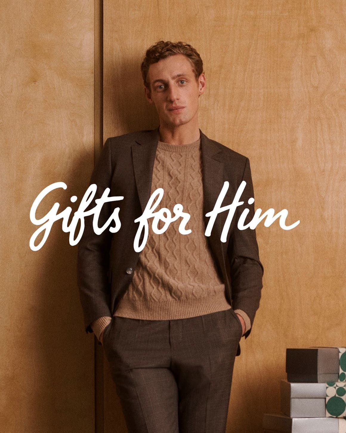 Gifts for him. A man wearing a blazer, sweater and pants.