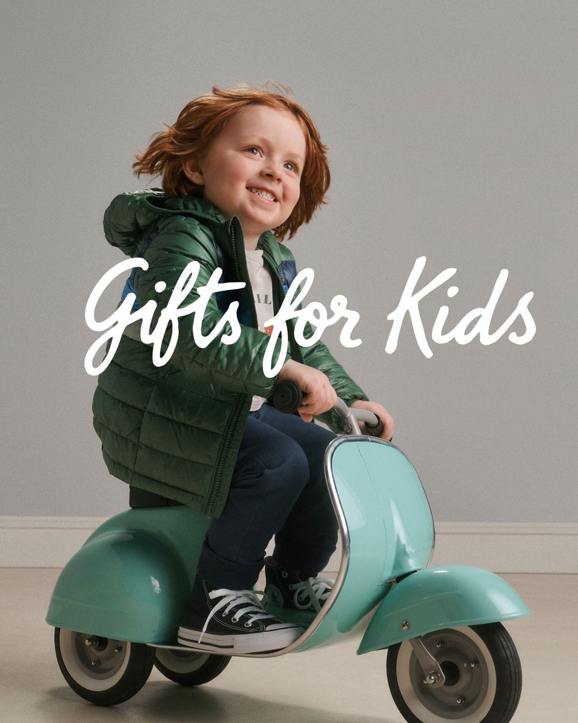 Gifts for kids. A kid riding a toy scooter.