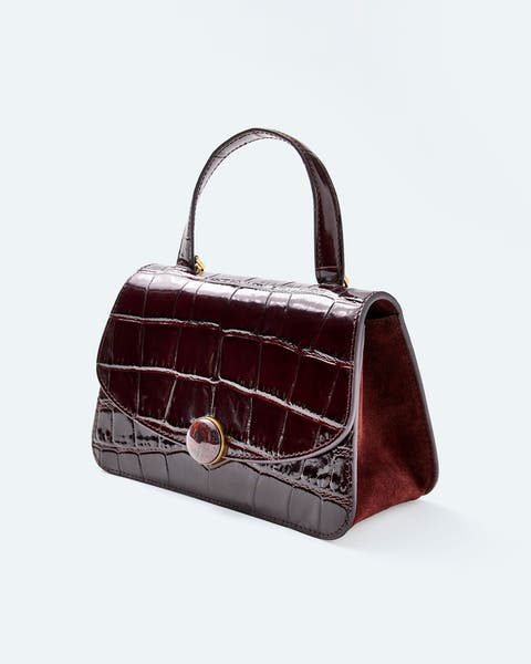 Burgundy croc-embossed leather top-handle bag with a jeweled clasp.