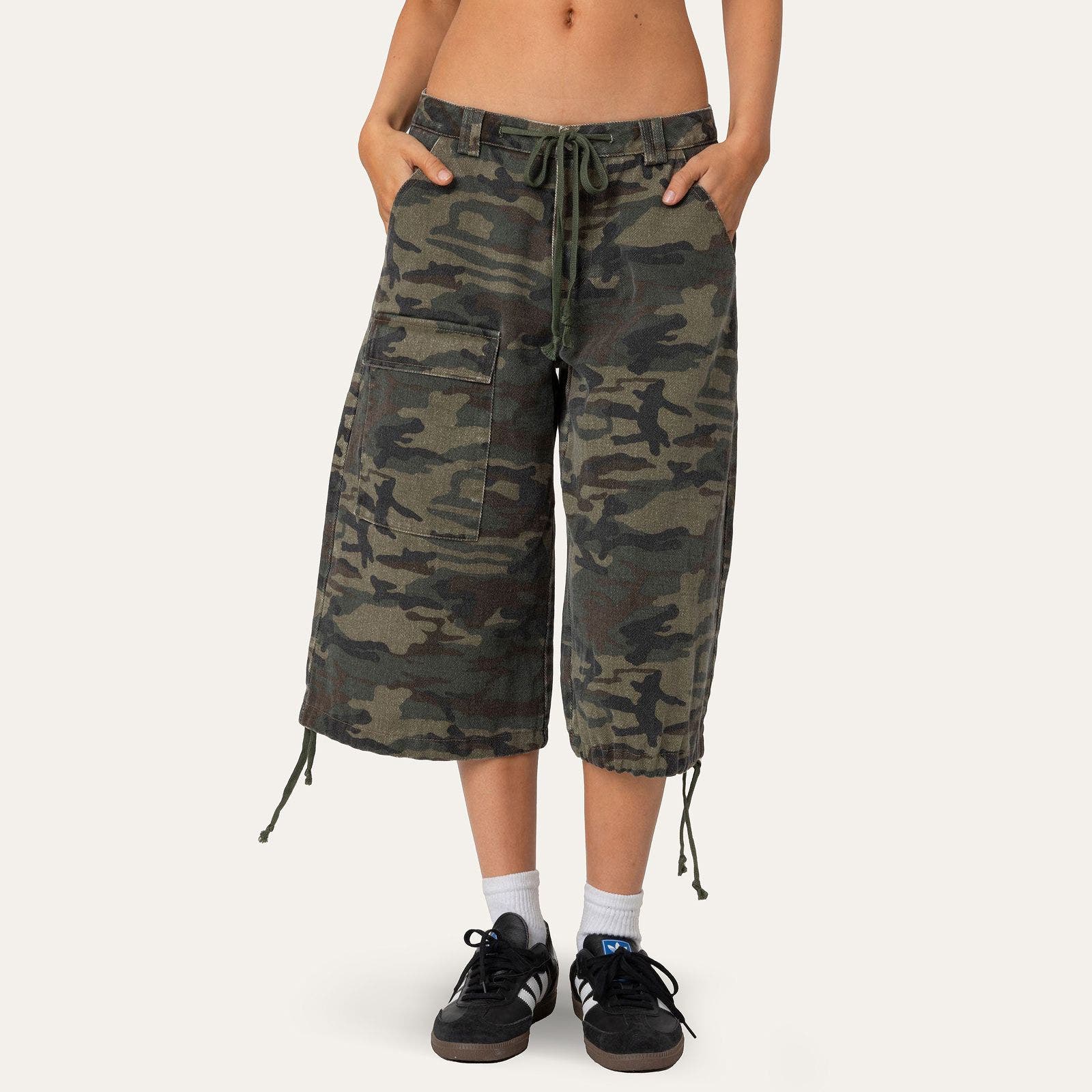 A woman wearing long, camo cargo shorts.