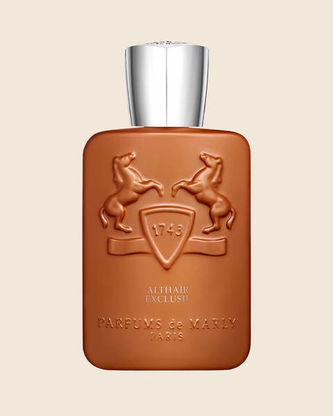Parfums de Marly perfume in a burnt orange bottle with a silver cap and a crest.