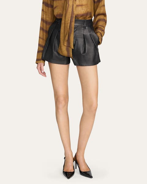 A woman wearing black leather shorts.