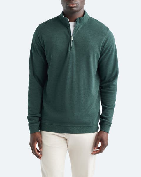 A man wearing green quarter-zip sweater.