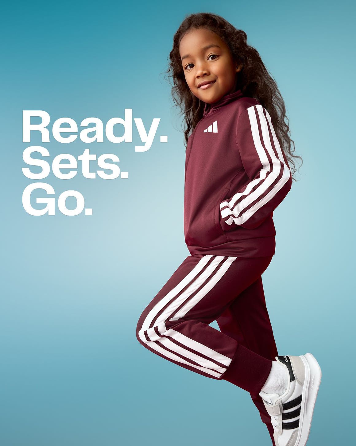 Ready. Sets. Go. A young girl wearing a track suit set.