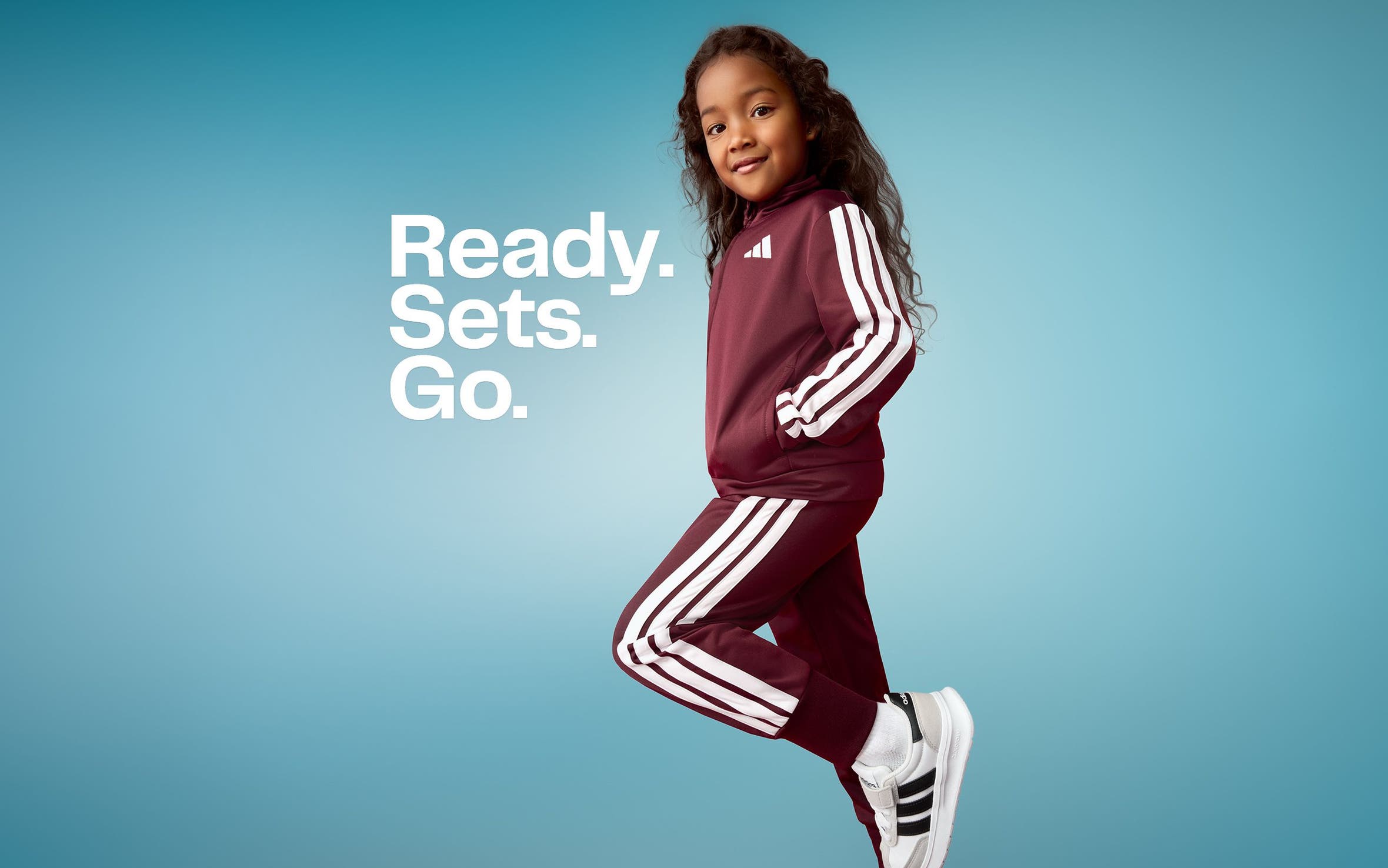 Ready. Sets. Go. A young girl wearing a track suit set.