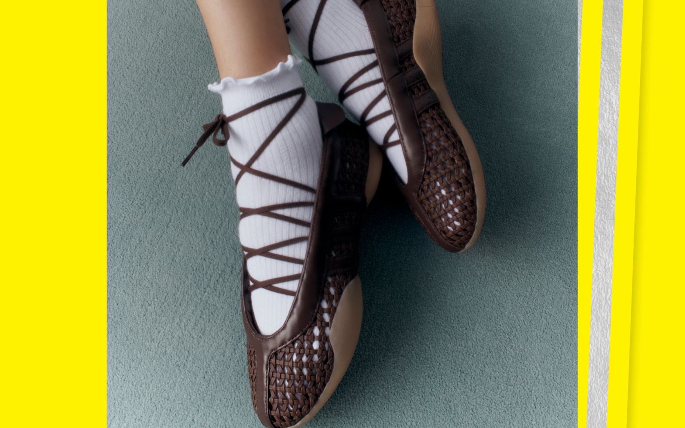 A woman in white lettuce-edged socks and dark woven lace up sneakers.