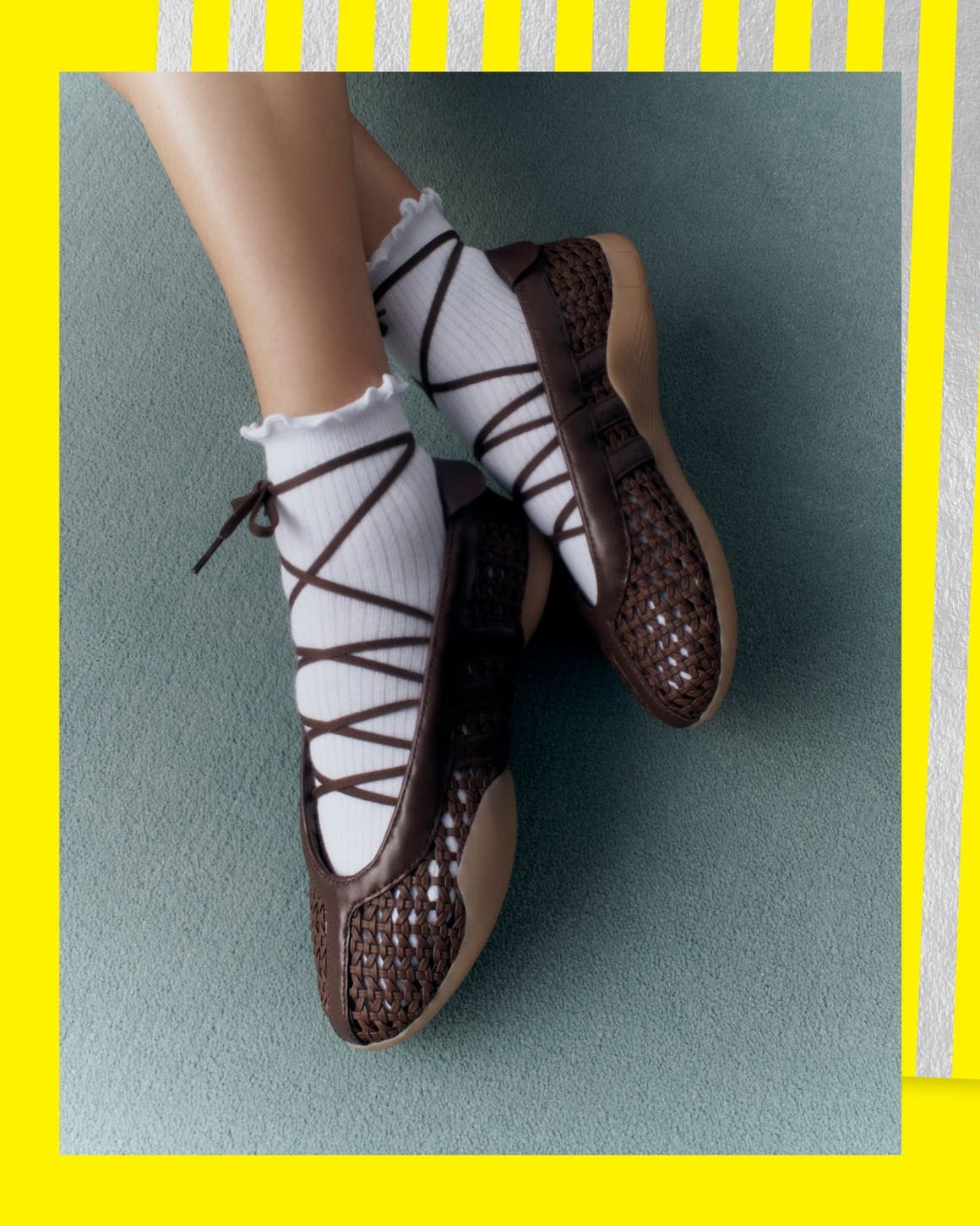 A woman in white lettuce-edged socks and dark woven lace up sneakers.