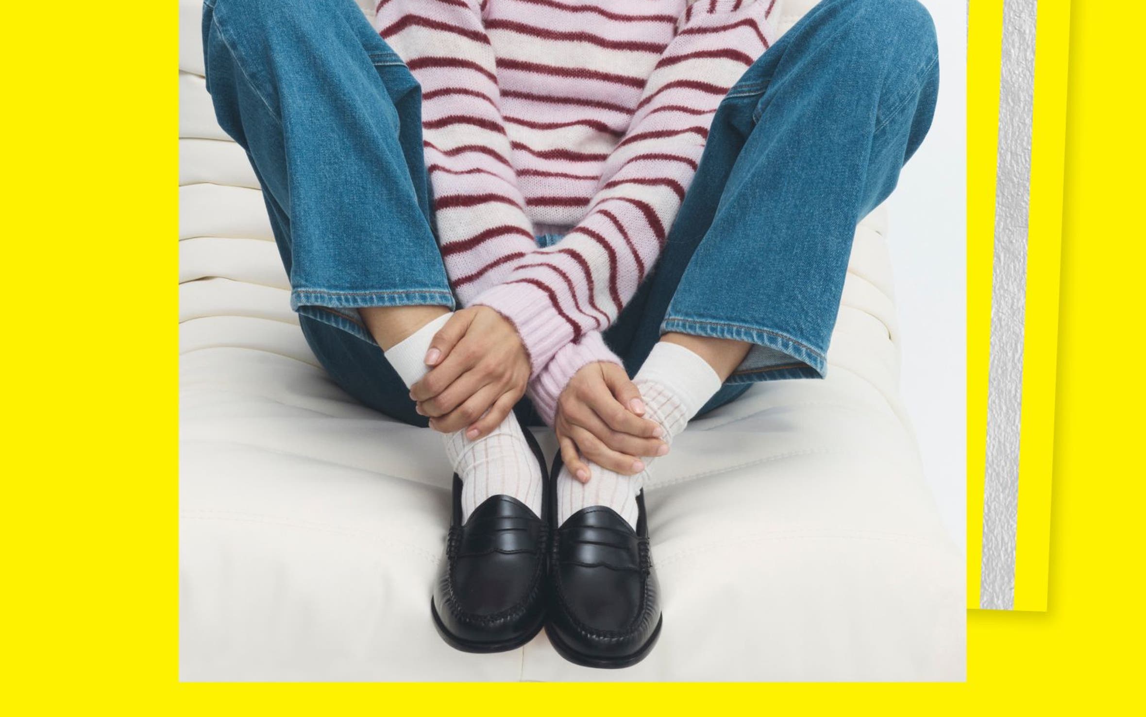 A woman in a striped shirt, jeans and dark leather loafers.
