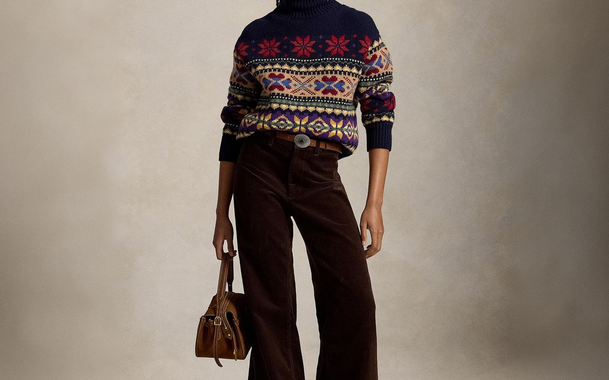 A woman wearing a fair isle sweater and brown corduroy pants.