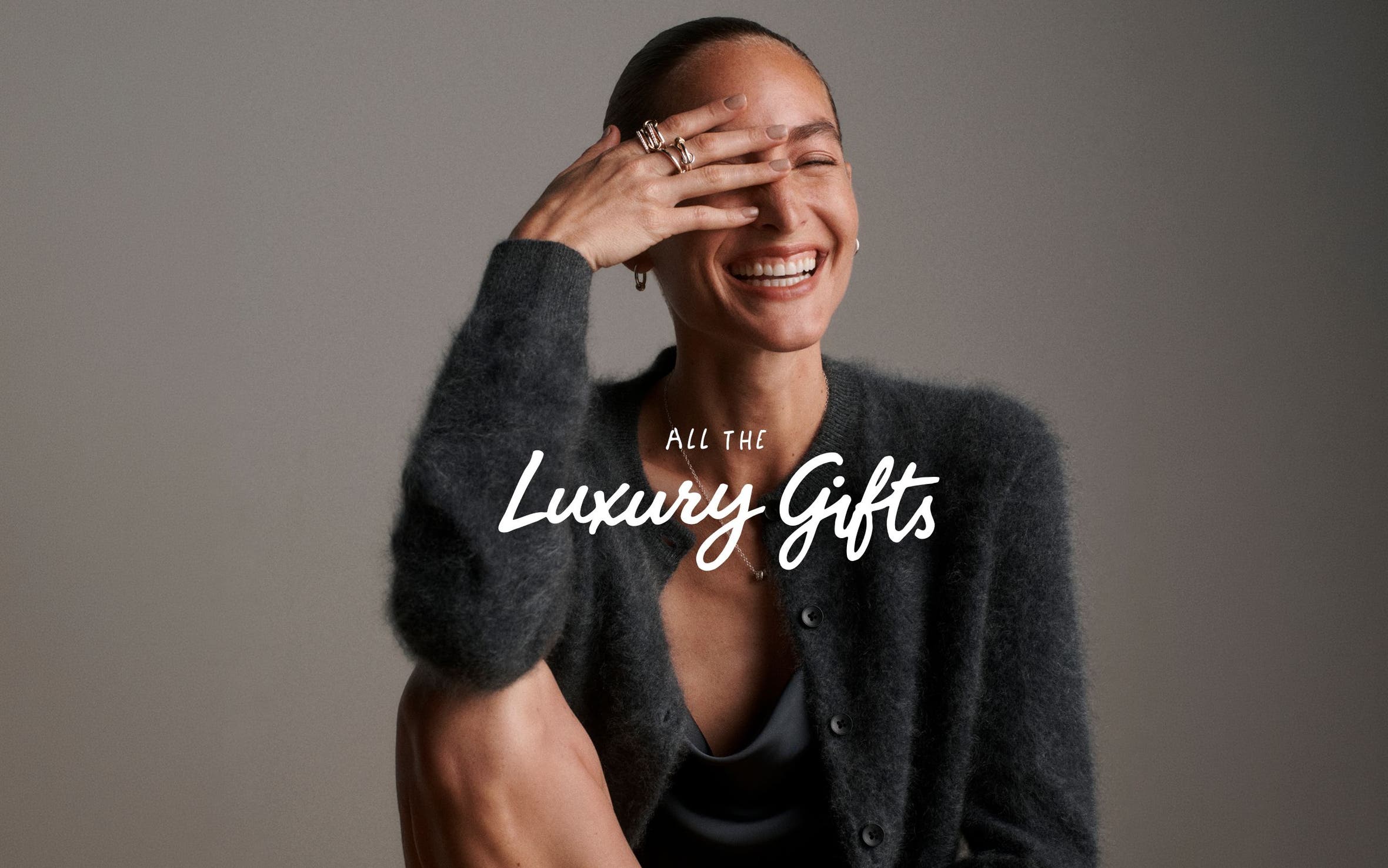All the luxury gifts. A woman wearing a sweater and jewelry.
