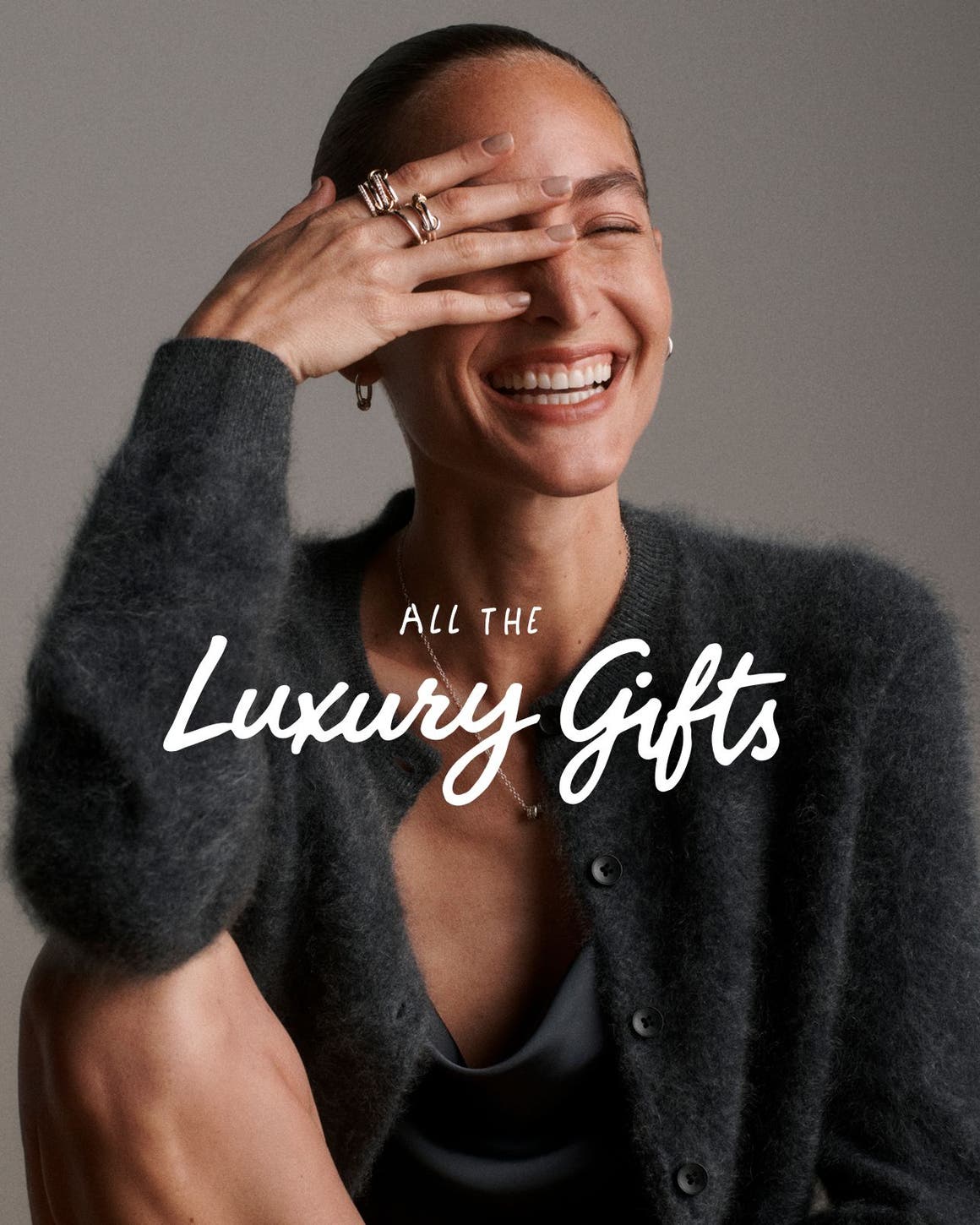 All the luxury gifts. A woman wearing a sweater and jewelry.