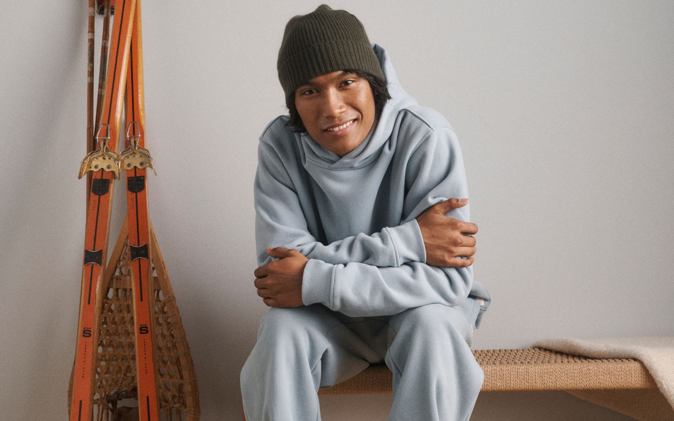 A man wearing a sweatshirt, sweatpants and beanie.