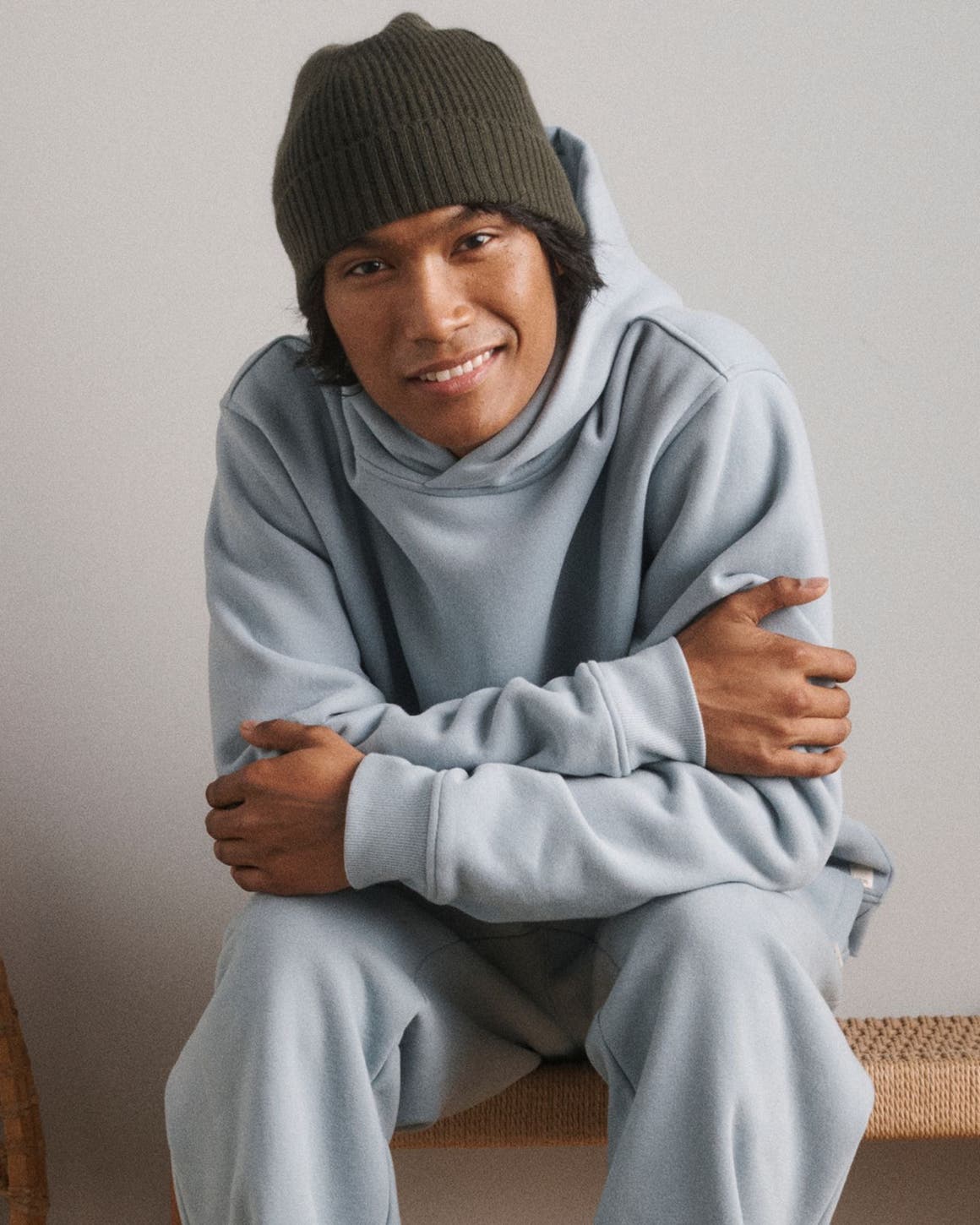 A man wearing a sweatshirt, sweatpants and beanie.