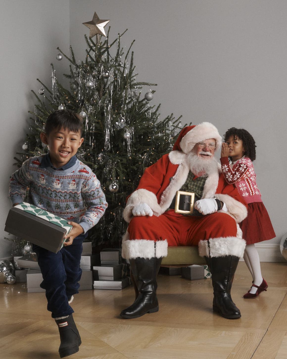 Kids with Santa in front of a Christmas tree.