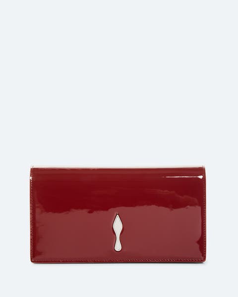 Red patent leather clutch with a silver-tone spike charm detail on the front.
