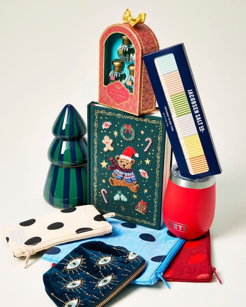 Holiday gifts including a travel mug, candle and zippered pouches.