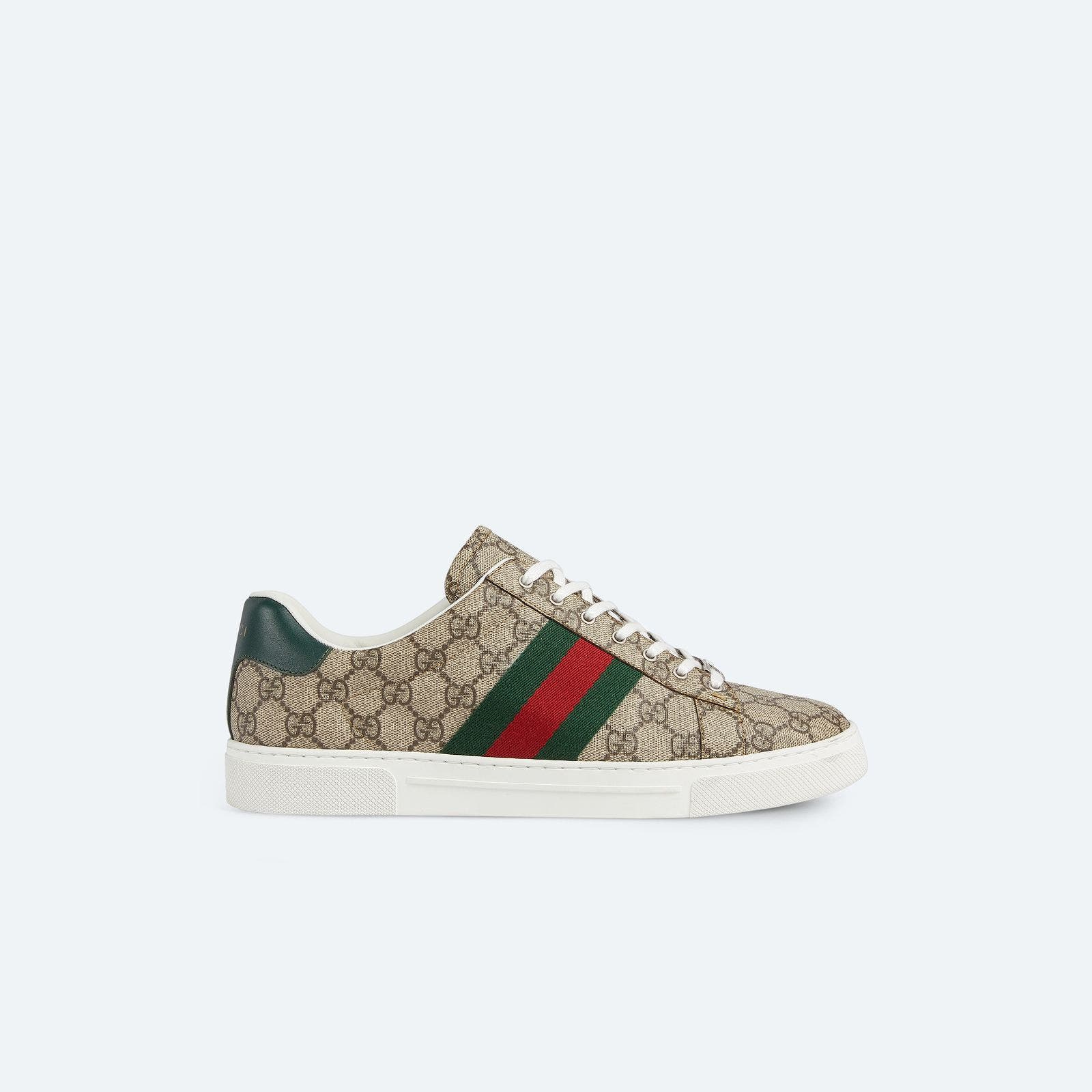 A logo-patterned low-top sneaker with striped webbing.