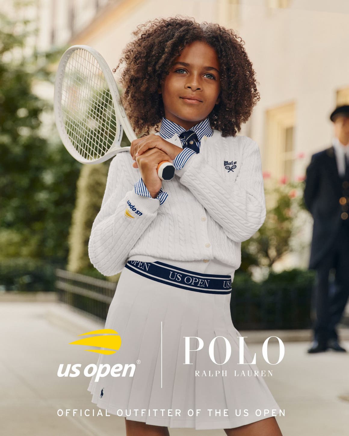 A girl wearing a wearing US Open x Polo Ralph Lauren pieces and holding a racket.