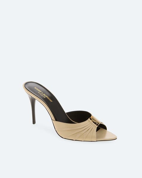 Beige leather mule sandal with a pointed open toe, ruched detailing, gold-tone hardware accent, and a stiletto heel.