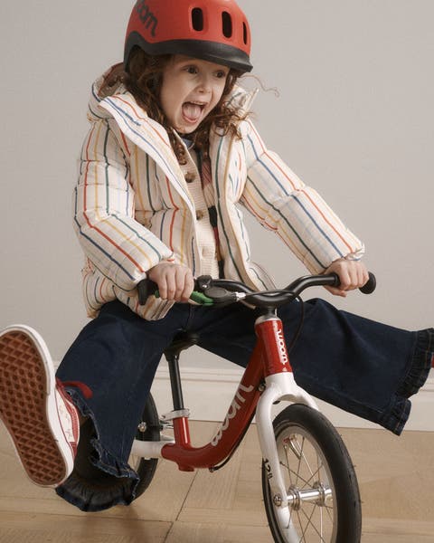 A girl riding a balance bike.