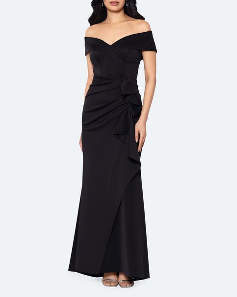 A woman in an off-the-shoulder black satin gown.