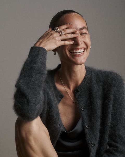 A woman wearing rings, earrings and a necklace.
