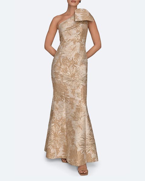 A woman wearing a champagne-colored one shoulder dress.