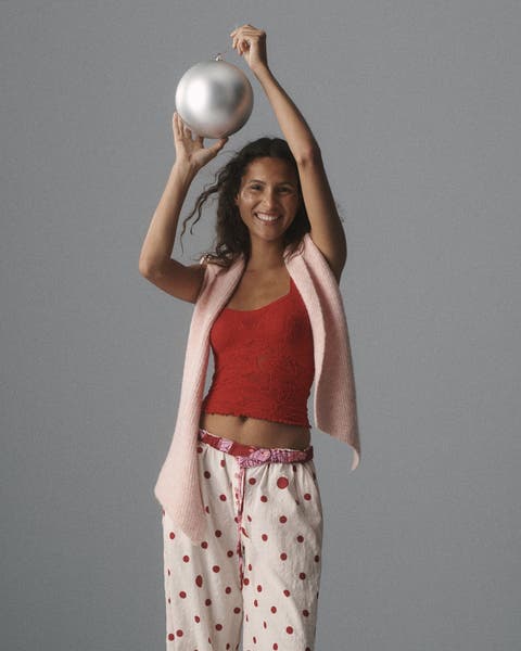 A woman wearing a camisole, scarf and PJ pants.