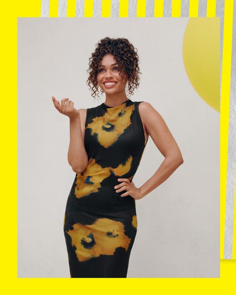 A woman wearing a black dress with yellow flowers. 