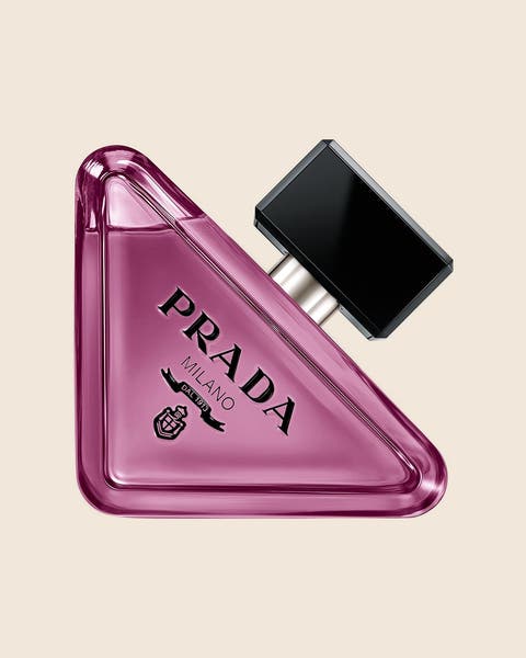 A Prada Milano fragrance in a purple triangle-shaped glass bottle with a black square cap.
