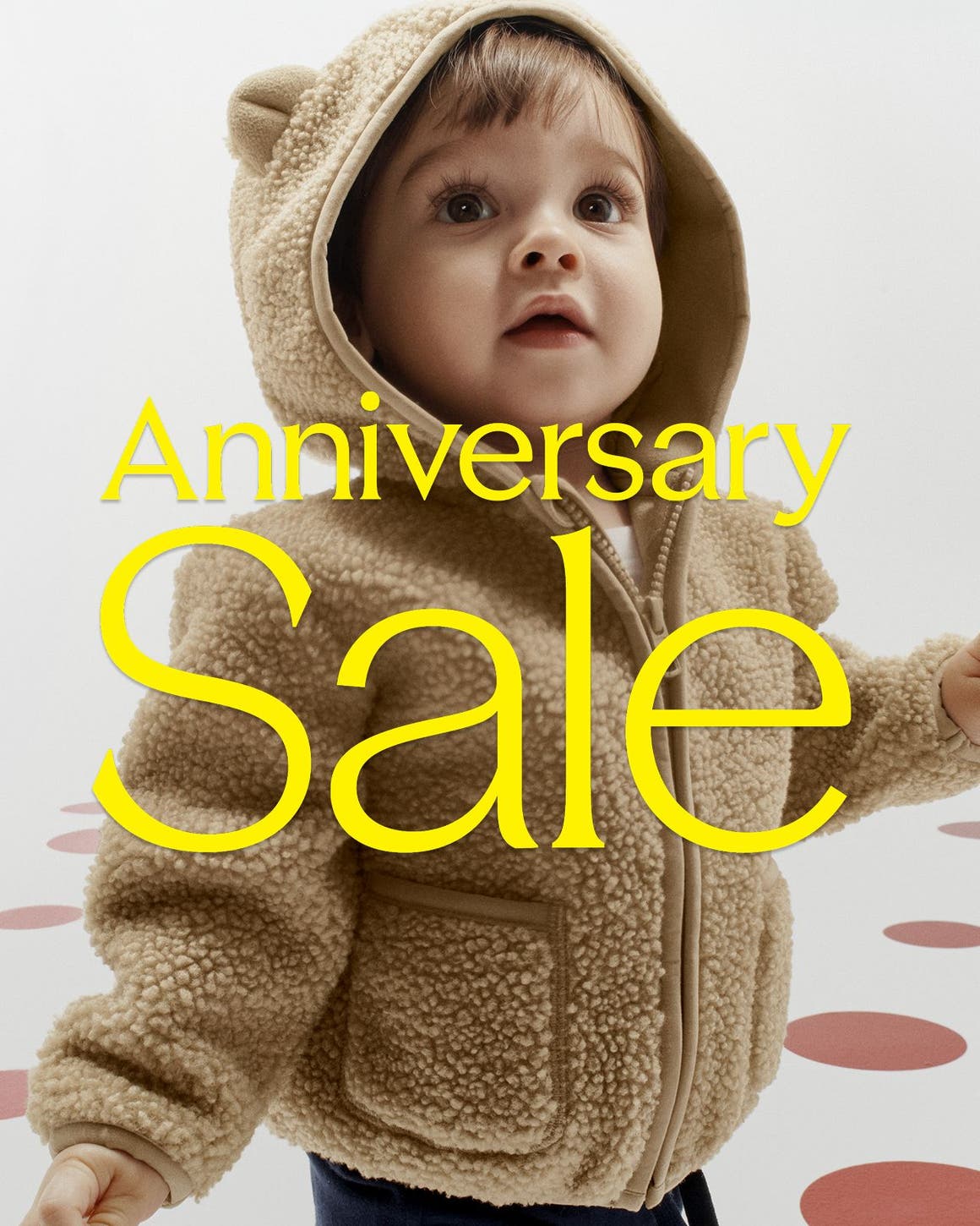 Anniversary Sale: a kid in a fuzzy bear hoodie.