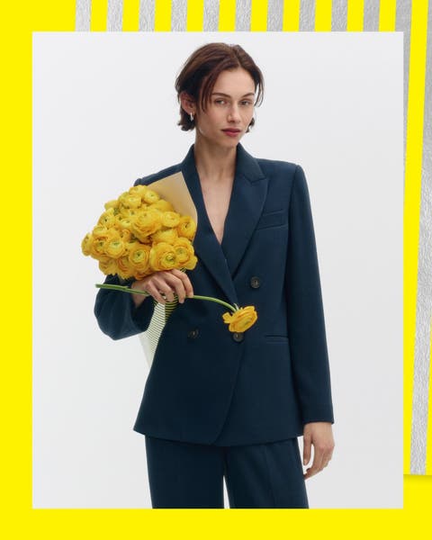 A woman in a navy double-breasted blazer and matching slacks.