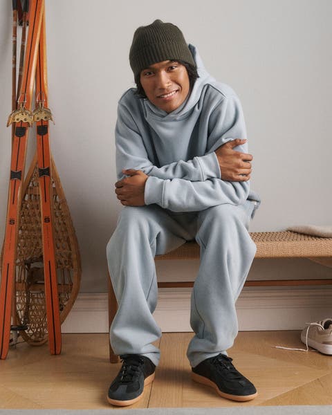 A man wearing a sweatsuit, beanie and sneakers.