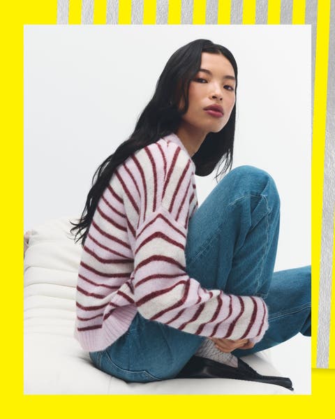 A woman wearing a striped sweater and jeans.