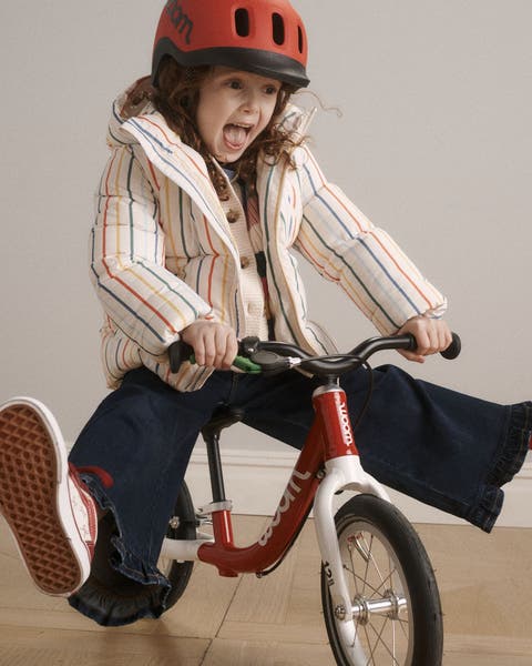 A girl riding a balance bike.