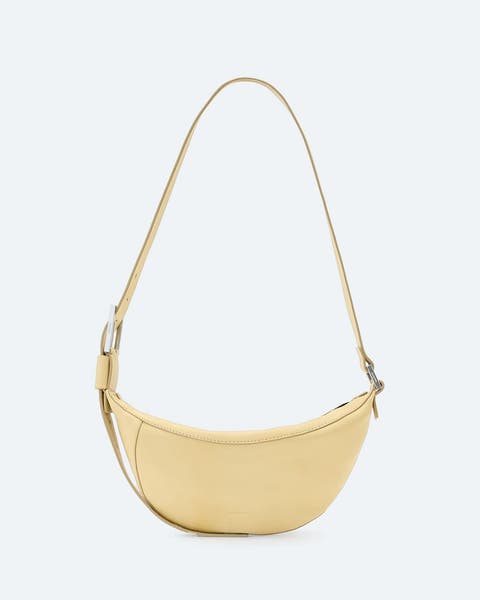 Pale yellow leather crossbody bag.
