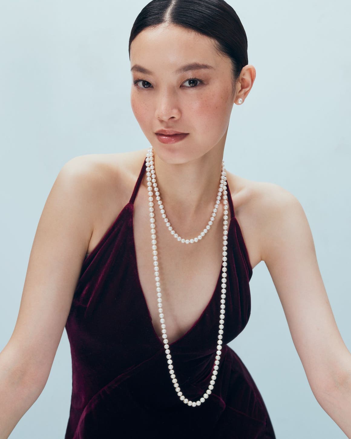 A woman wearing a pearl necklace.