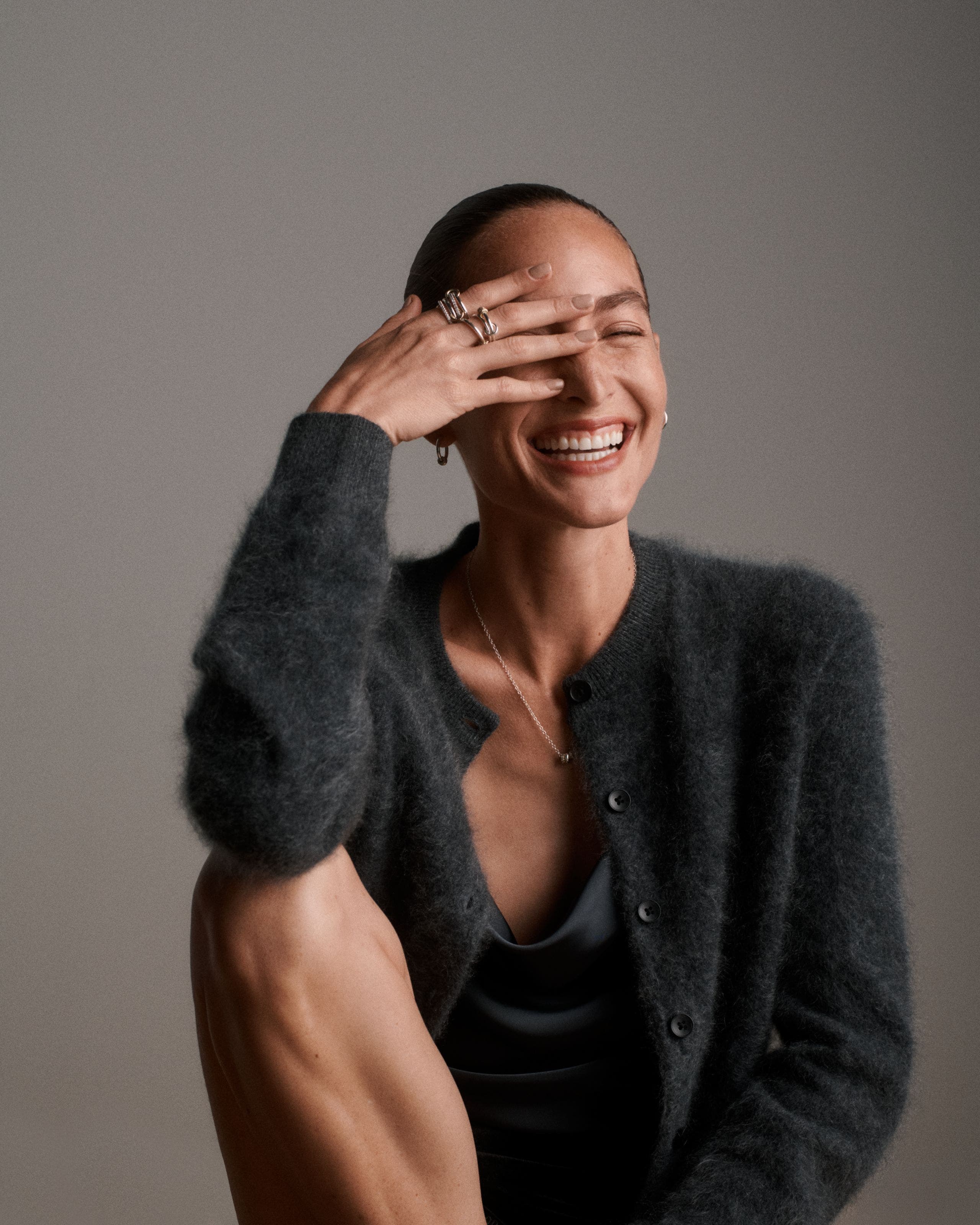 A woman wearing a grey cardigan.
