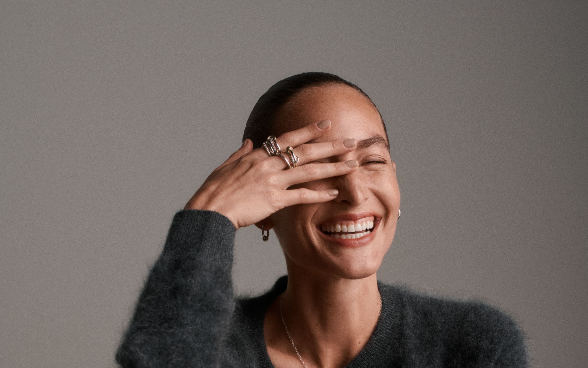 A woman wearing a grey cardigan.