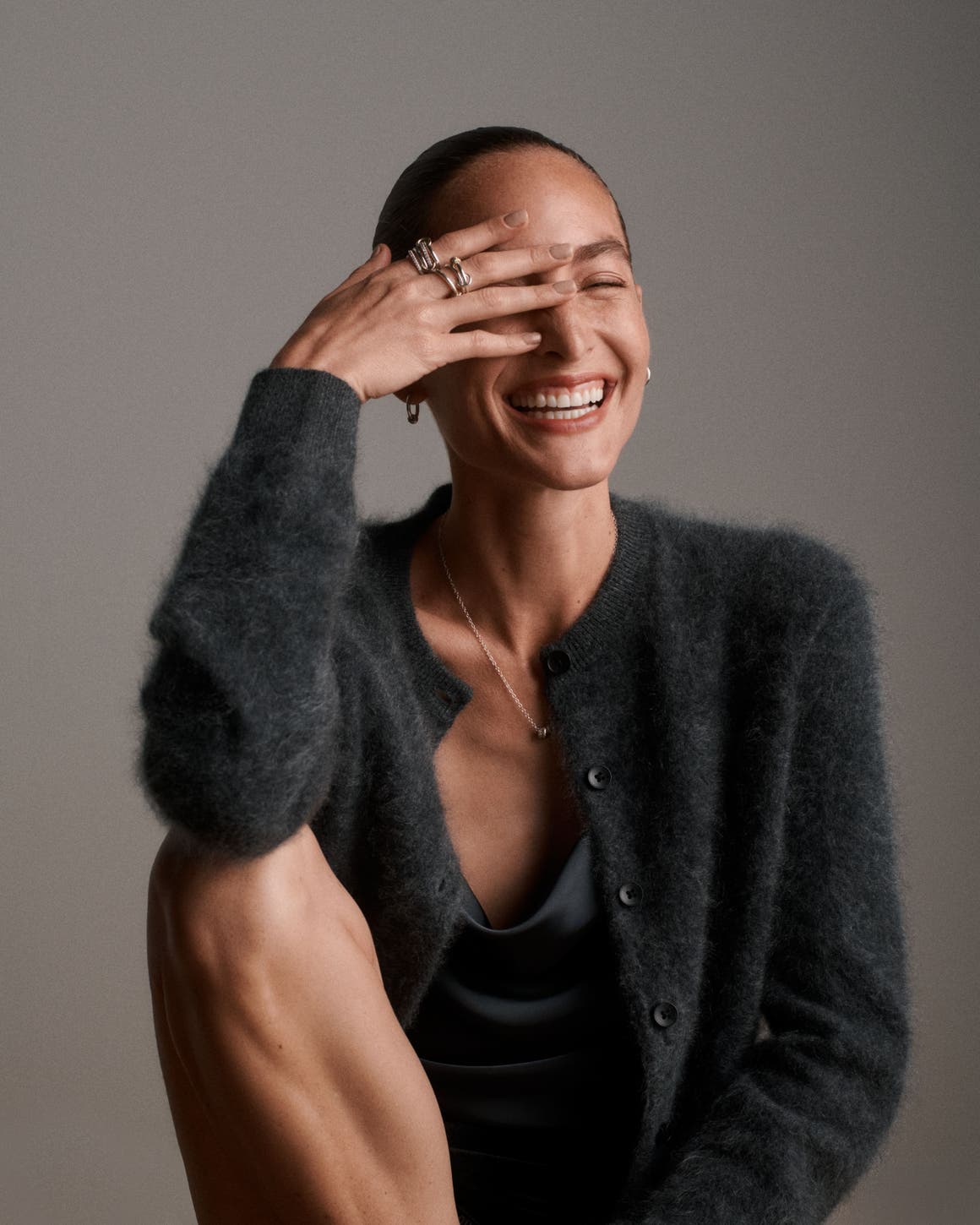 A woman wearing a grey cardigan.