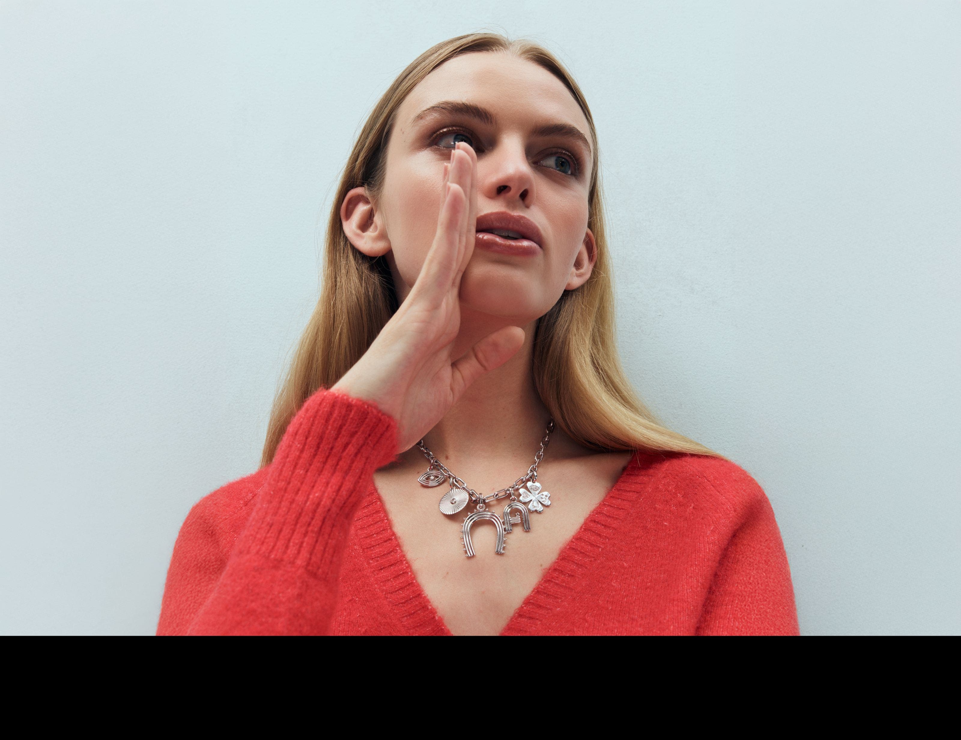 A woman wearing a charm necklace.