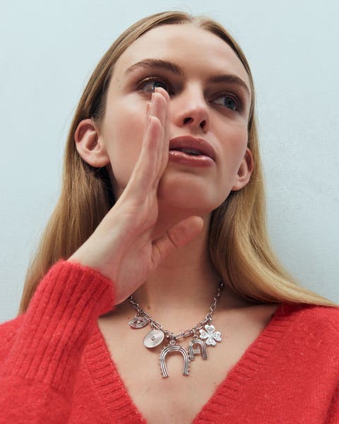 A woman wearing a charm necklace.